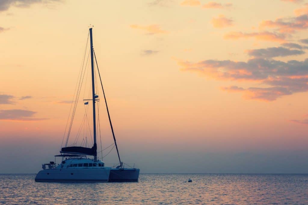 Catamaran sailing during sunset 